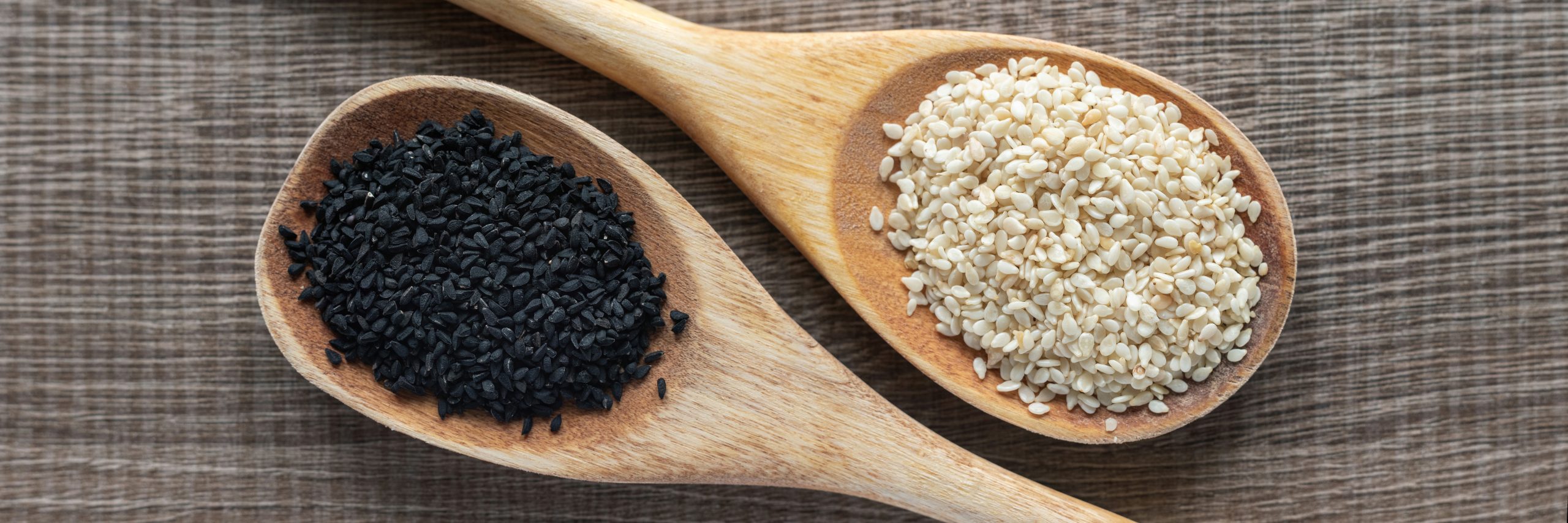 sesame seeds in a wooden spoon, close up.